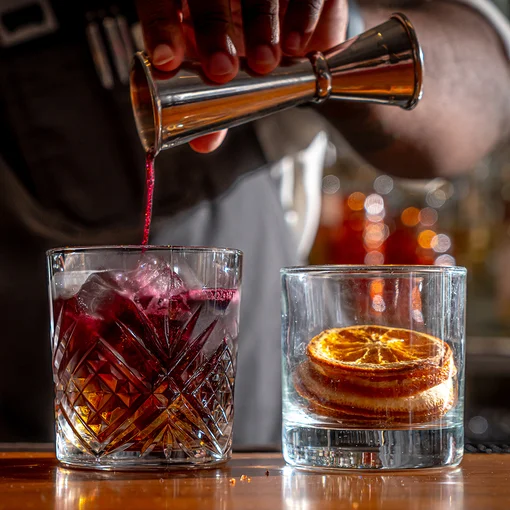 Bartender pouring drink over ice