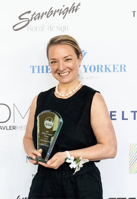 Chef Morgan Jarrett posing for a photo while holding an award